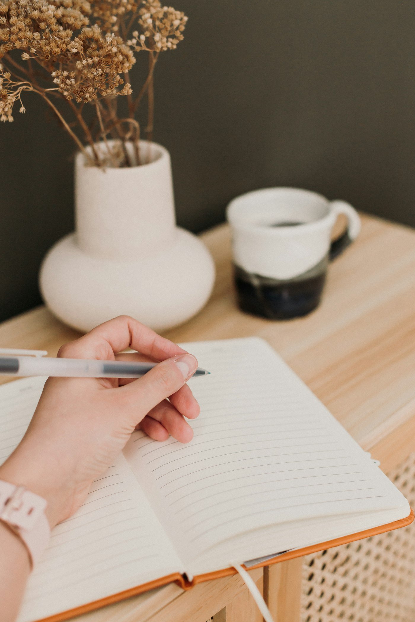 Person writing in a notebook, planning the week with intention