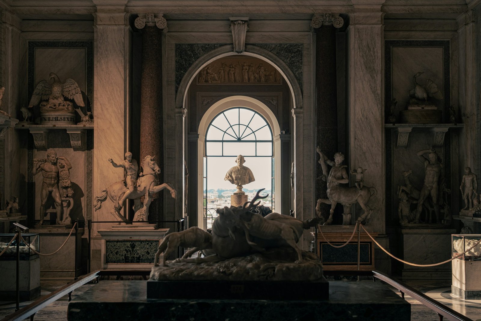 Classical marble statue beside a tall window, the Stoic ideal behind every Ash and Iron planner